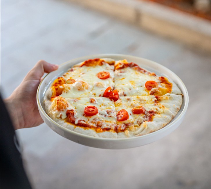 Hand‑stretched pizza with cherry tomatoes